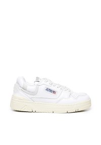 Zapatilla blanca de piel con suela de goma gruesa, que presenta un diseño cosido, perforaciones y un logotipo en el costado.