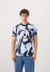 Modrý a čierny vzorovaný dres s okrúhlym výstrihom, krátkymi rukávmi a ružovou lebkou s logom "Vodacom" na prednej strane.