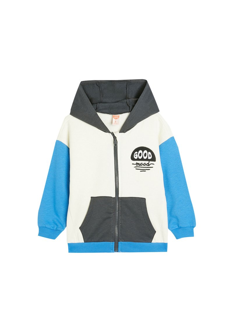 Chaqueta con capucha y cremallera en crema, gris y azul. Cuenta con bolsillos frontales, diseño de texto "GOOD", puños acanalados y una textura de tela suave.