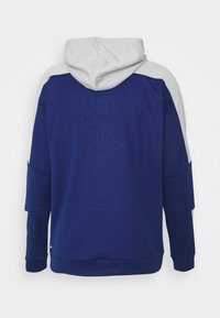 Marinblå hoodie med ljusgrå axelkonturer, med en strukturerad mönstrad baksida, kenguruficka och justerbar dragsko på huvan.