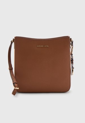 Braune Lederhandtasche von Michael Kors mit verstellbarem Träger und goldfarbenen Beschlägen auf einfachem, hellem Hintergrund.