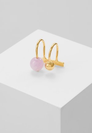 Boucles d'oreilles en ton or avec crochets en forme de U, comprenant une pierre ronde rose et une petite perle dorée ronde, présentées sur un socle blanc.