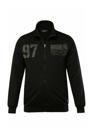 Veste noire zippée en tissu texturé, ornée de graphiques imprimés "BROOKLYN" et "97" dans une couleur contrastante sur le devant.