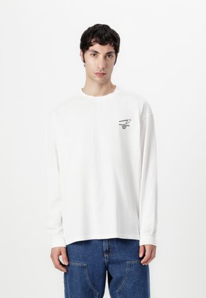 Witte lange mouwen T-shirt gemaakt van katoen, met een kleine zwarte afbeelding op de borst. Ruime pasvorm met ribgebreide manchetten en een ronde halslijn.
