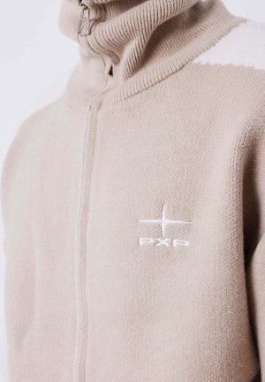 Suéter de punto en color beige claro, con cremallera y cuello alto, y logo bordado en blanco "PXP" en el pecho.