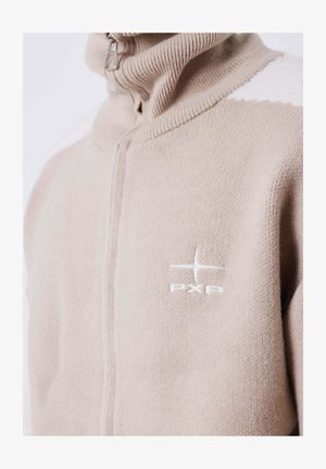 Suéter de punto en color beige claro, con cremallera y cuello alto, y logo bordado en blanco "PXP" en el pecho.