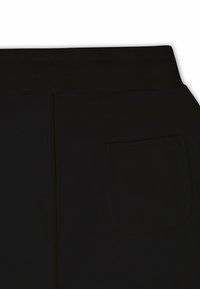Black fabric joggers feature a wide ribbed waistband and a single stitched back pocket. The surface is smooth and matte.