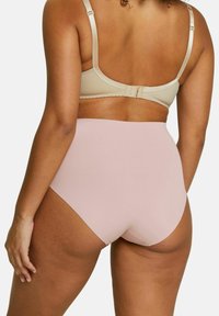 Soutien-gorge beige avec bretelles réglables et fermeture à crochet, associé à une culotte rose taille haute au tissu lisse et à la conception sans couture.