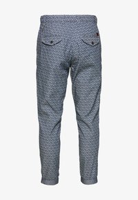 Modré vzorované kalhoty s geometrickým motivem, s dvěma zadními kapsami na knoflíky a ohrnutými lemy u kotníků.