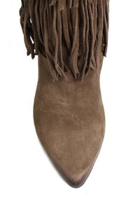 Brązowy zamszowy botek za kostkę z ostrym noskiem i frędzlami wzdłuż górnej krawędzi. Gładka faktura z delikatnym połyskiem.