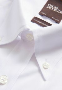 Valkoinen puuvillapaita, jossa on levinneet kaulukset, slim fit -muotoilu ja valkoiset napit. Tagi ilmoittaa brändiksi "Oscar Jacobson" ja koon.