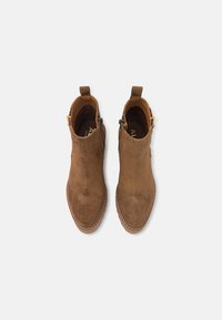 Ruske nubuk ankle boots med en glat overflade, spids tå, sidelommer og trækhæfte på hælen for nem påtagning.