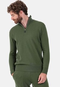 Pull-over vert olive avec col zippé au quart, ourlet et poignets côtelés, fabriqué en tissu doux et texturé.