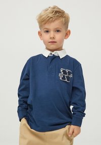 Granatowa, długorękawowa koszulka polo z białym kołnierzykiem i haftowanym logo "N". Wykonana z bawełny o miękkiej fakturze, z zapięciem na guziki.