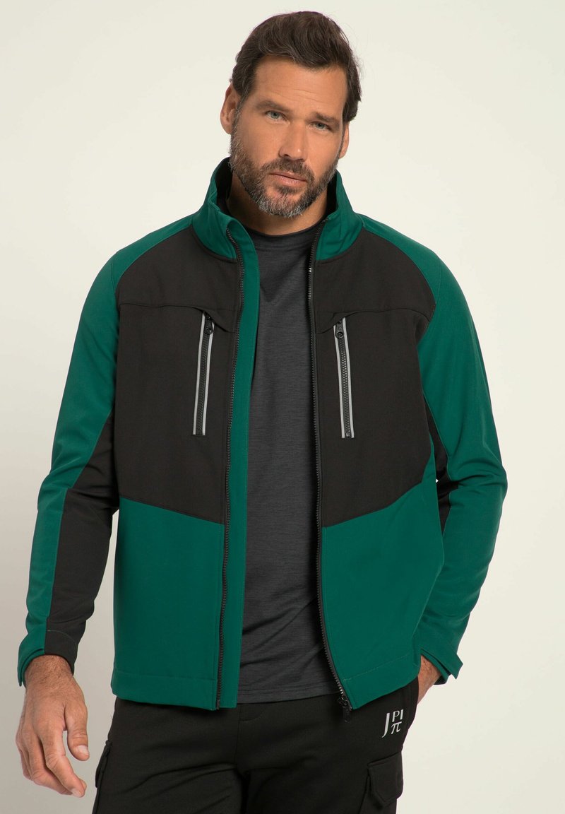 Zip-up jacka i svart och teal, tillverkad av mjukt tyg. Har två fickor med dragkedja på bröstet och en hög krage, med en figurnära design.