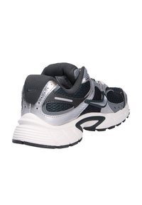 Zapatilla de correr para hombres con parte superior de malla en negro con acentos plateados, suela blanca acolchada y suela exterior texturizada en negro. Presenta detalles reflectantes.