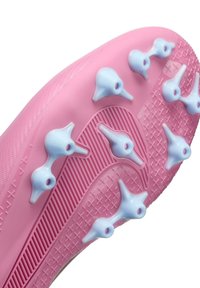Różowa podeszwa sportowego buta z jasnoniebieskimi kołkami. Teksturowana powierzchnia z żebrowanymi akcentami i wzorzystą podkładką zapewniającą przyczepność.