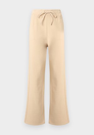 Pantaloni largi bej din material de trening, cu talie elastică și șnur, cusături laterale subtile și un logo discret al brandului aproape de talie.