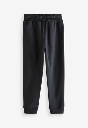 Svarta träningsoveraller i mjukt material, med ett elastiskt midjeband och ribbade muddar vid anklarna för en åtsittande look. Slät textur.