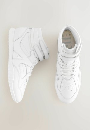 Visoke bele teniske čevlje izdelane iz sintetičnega materiala z gladko površino, opremljene z več luknjami, trakovi in teksturiranim gumijastim podplatom.