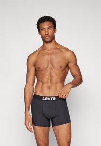 Svarta Levi's kalsonger med logoband, i bomull, med en figurnära design och slät textur, bärs av en man med en muskulös kroppsbyggnad.