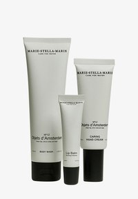Quatre tubes de soins pour la peau en gris mat, étiquetés "Marie-Stella-Maris", comprennent un gel douche, un baume à lèvres et une crème pour les mains. Design élégant, détails de texte subtils.