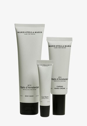 Vier Hautpflege-Tuben in mattem Grau, beschriftet mit "Marie-Stella-Maris", enthalten Duschgel, Lippenbalsam und Handcreme. Elegantes Design, dezente Textdetails.