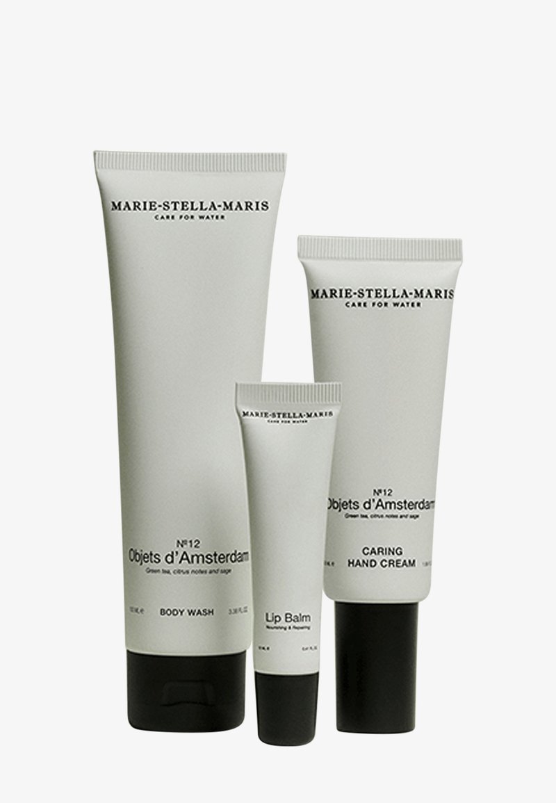 Quatre tubes de soins pour la peau en gris mat, étiquetés "Marie-Stella-Maris", comprennent un gel douche, un baume à lèvres et une crème pour les mains. Design élégant, détails de texte subtils.