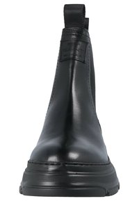 Botas de tobillo de cuero negro con un acabado brillante, paneles laterales elásticos y una asa. Presenta una suela texturizada para mejor agarre. Marca GANT visible.