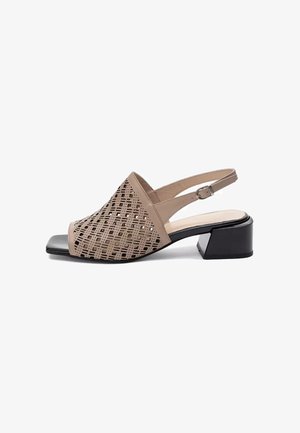 Beżowy sandał typu slingback z odkrytymi palcami, geometrycznym wzorem wycięć, regulowanym paskiem z klamrą i niskim czarnym obcasem blokowym.