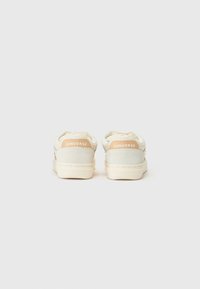 White and beige sneakers with a smooth texture, featuring a rubber sole and "CONVERSE" branding on the heel. Simple design with no patterns.