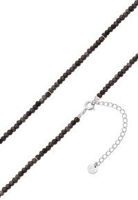 Karoliukų kaklo papuošalas, pagamintas iš tamsiai pilkų akmenų, su sidabriniu užsegimu ir pratęsimo grandinėle su maža žaviu detaliu. Lygus paviršius, apvalūs karoliukai.