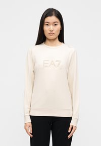 Μπεζ φούτερ μακρυμάνικο κατασκευασμένο από απαλή ύφανση με λογότυπο "EA7" διακοσμημένο με τρουκ, στρογγυλή λαιμόκοψη και ελαστικές μανσέτες.