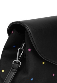 Černá taška s hladkou koženou klopou a tělem z látky s puntíkovaným vzorem v růžové, modré a žluté barvě. Viditelné stříbrné kovové detaily.