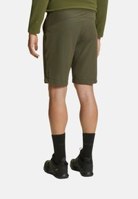 Pantaloni corti da esterno verde oliva con una vestibilità comoda, due tasche laterali e orlo risvoltato, abbinati a calzini e scarpe nere.