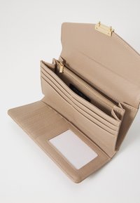 Béžová peněženka z umělé kůže se zlatými detaily, několika přihrádkami na karty, zipovou kapsou a průhledným oknem na doklady. Texturovaný povrch.