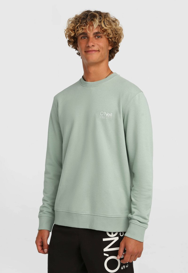 Miętowa bluza z długimi rękawami, prążkowanym okrągłym dekoltem i logo O'Neill na piersi. Do tego czarne spodnie z białymi napisami.