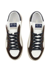 Un paio di sneakers bianche con sovrapposizioni in suede marrone scuro, lacci blu navy e etichetta del marchio sulla linguetta, viste dall'alto su uno sfondo bianco.