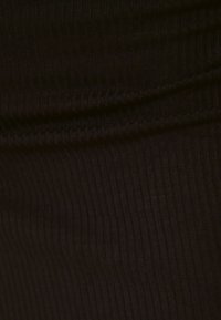 Tissu noir côtelé avec une texture lisse, présentant des lignes verticales et une légère élasticité. Le matériau est doux et moulant.