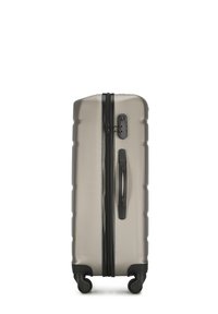 Harde koffer in metallic zilver met een gestructureerde afwerking, voorzien van een centrale rits, een zijhandvat en vier zwarte wielen voor mobiliteit.