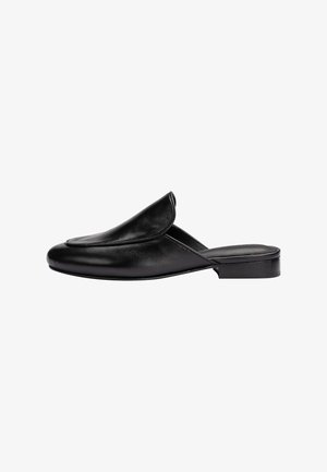 Mule en cuir noir à enfiler avec un petit talon et un rabat supérieur relevé et plié, vue de côté sur fond blanc.