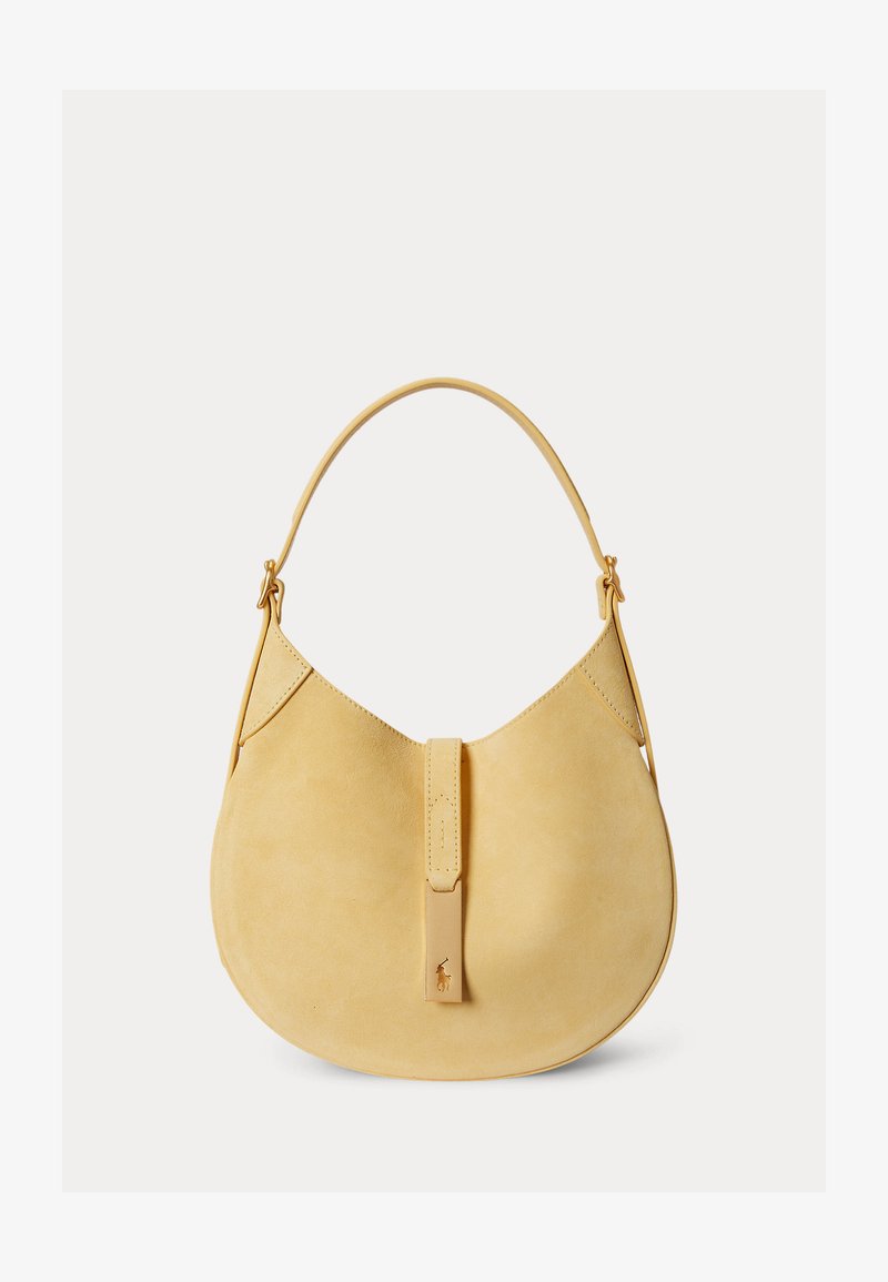 Béžová semišová kabelka v tvare polmesiaca s jedným remienkom a prednou klapkou so zmenšeným vyrazeným logom.