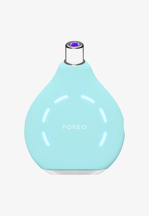 Light blue silicone skincare device with a teardrop shape, metallic silver nozzle, and circular LED lights, featuring "FOREO" logo.