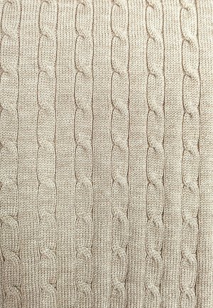 Jasnobeżowa dzianina z teksturowanym wzorem warkocza z powtarzającymi się owalnymi kształtami, nadającymi strukturę prążkowan ą.