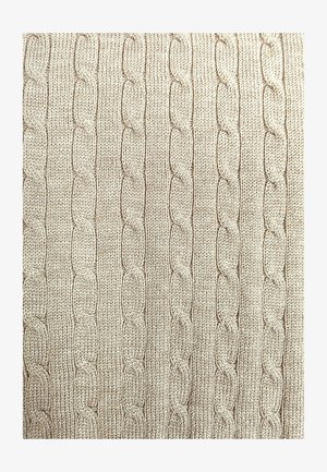 Jasnobeżowa dzianina z teksturowanym wzorem warkocza z powtarzającymi się owalnymi kształtami, nadającymi strukturę prążkowaną.