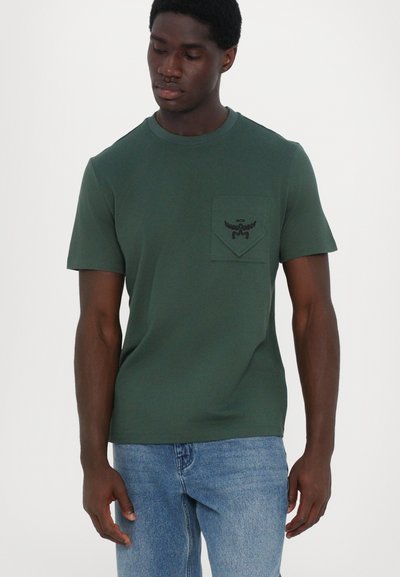 Žalias medvilninis T shirt'as su apvalia kaklaraiščiu, trumpomis rankovėmis ir krūtinės kišenėle, su juodu siuvinėtų logotipu ir sparnų dizainu.