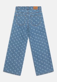 Jeans in denim azzurro con un motivo ripetuto di logo bianco. Presentano una vita quadrata, due tasche posteriori e gambe dritte e larghe.
