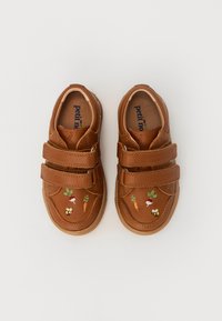 Ruske nahkaste čevlje za otroke z dvema Velcro trakoma, ki imajo izvezene motive korenja, redkvice, cvetov in čebele na straneh.