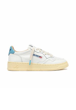 Sneaker in pelle bianca con suola beige, dettaglio blu sul tallone, lacci beige e piccolo logo con bandiera americana sul lato.