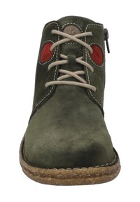 Zielony zamszowy botek do kostki z czerwonymi okrągłymi akcentami, beżowymi sznurówkami i bocznym zamkiem błyskawicznym. Gumowa podeszwa ze szczegółami szycia wokół krawędzi.
